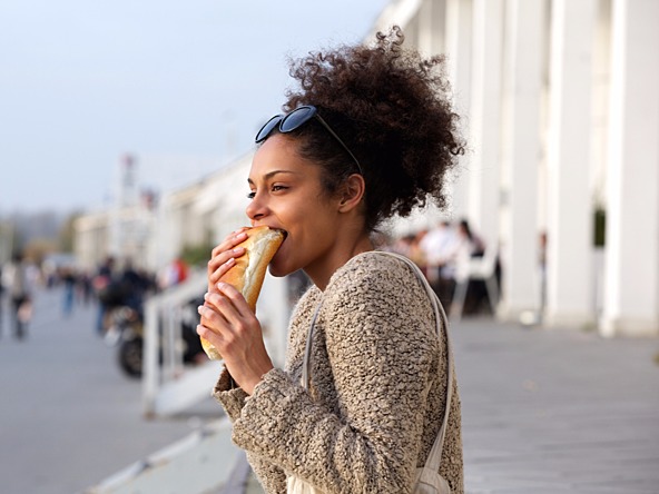 Woman eating on the go_crop